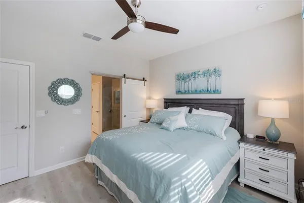 a bedroom with a bed and a lamp on the dresser