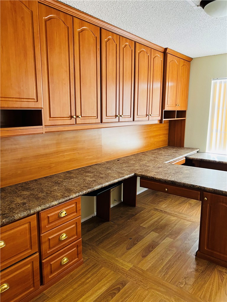 12771 Ponderosa Ranch Road Victorville, CA 92392 - Photo 14 of 23 a kitchen with granite countertop wooden cabinets a sink and a counter top space