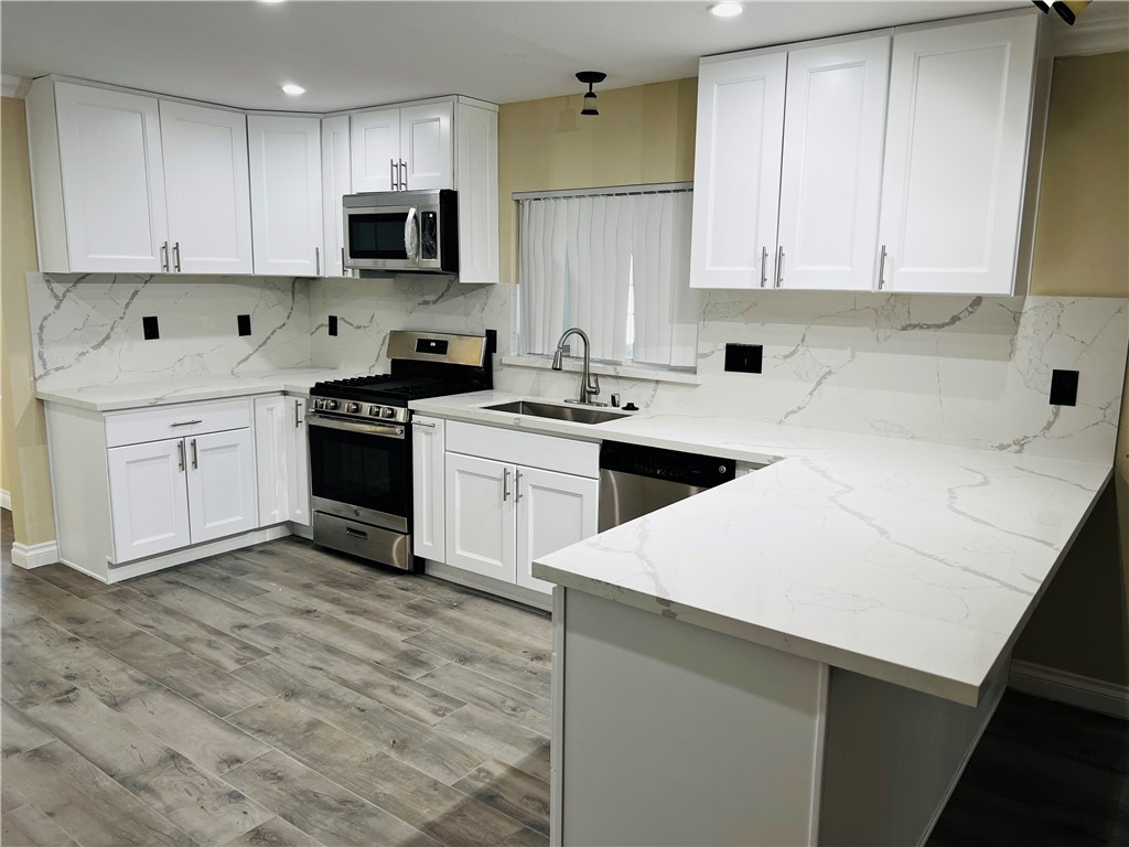 12771 Ponderosa Ranch Road Victorville, CA 92392 - Photo 5 of 23 a kitchen with cabinets appliances a sink and a counter top space