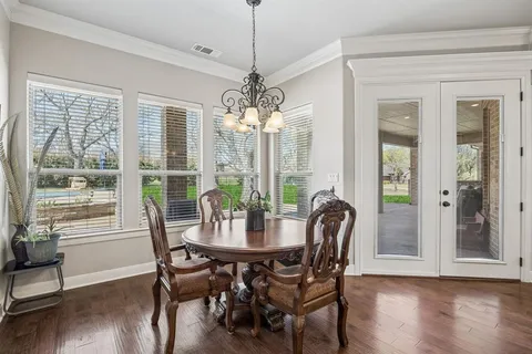 a view of a dining room with furniture wooden floor and chandelier