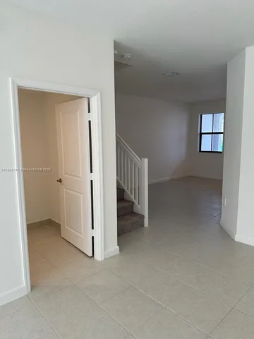 a kitchen with stainless steel appliances a refrigerator a stove a sink and white cabinets