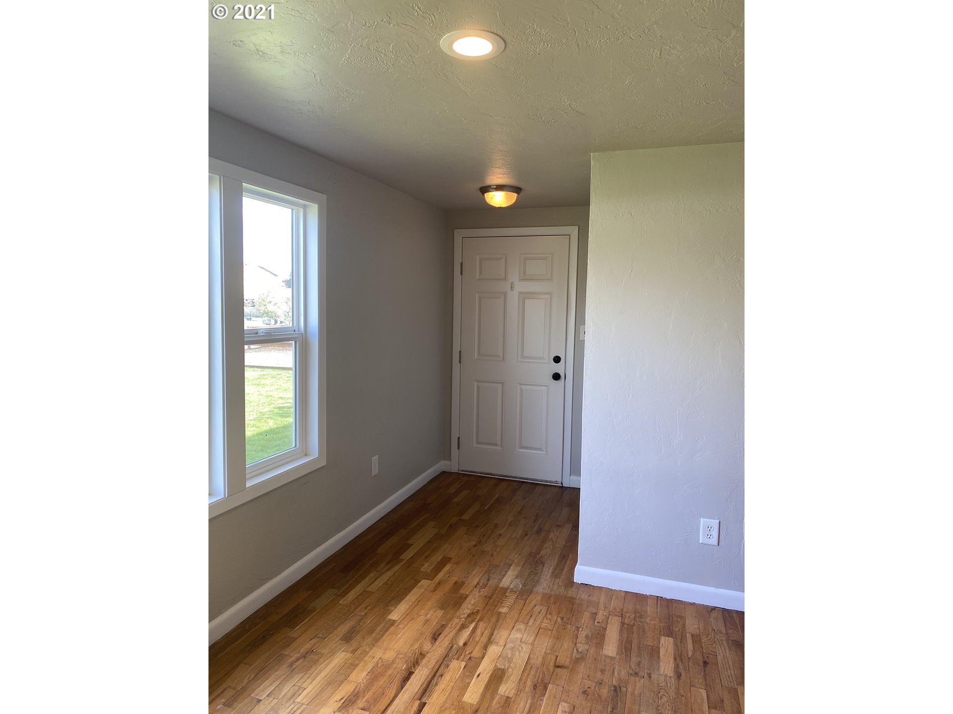 504 38th Street Springfield, OR 97478 - Photo 6 of 18 a view of an empty room with wooden floor and a window