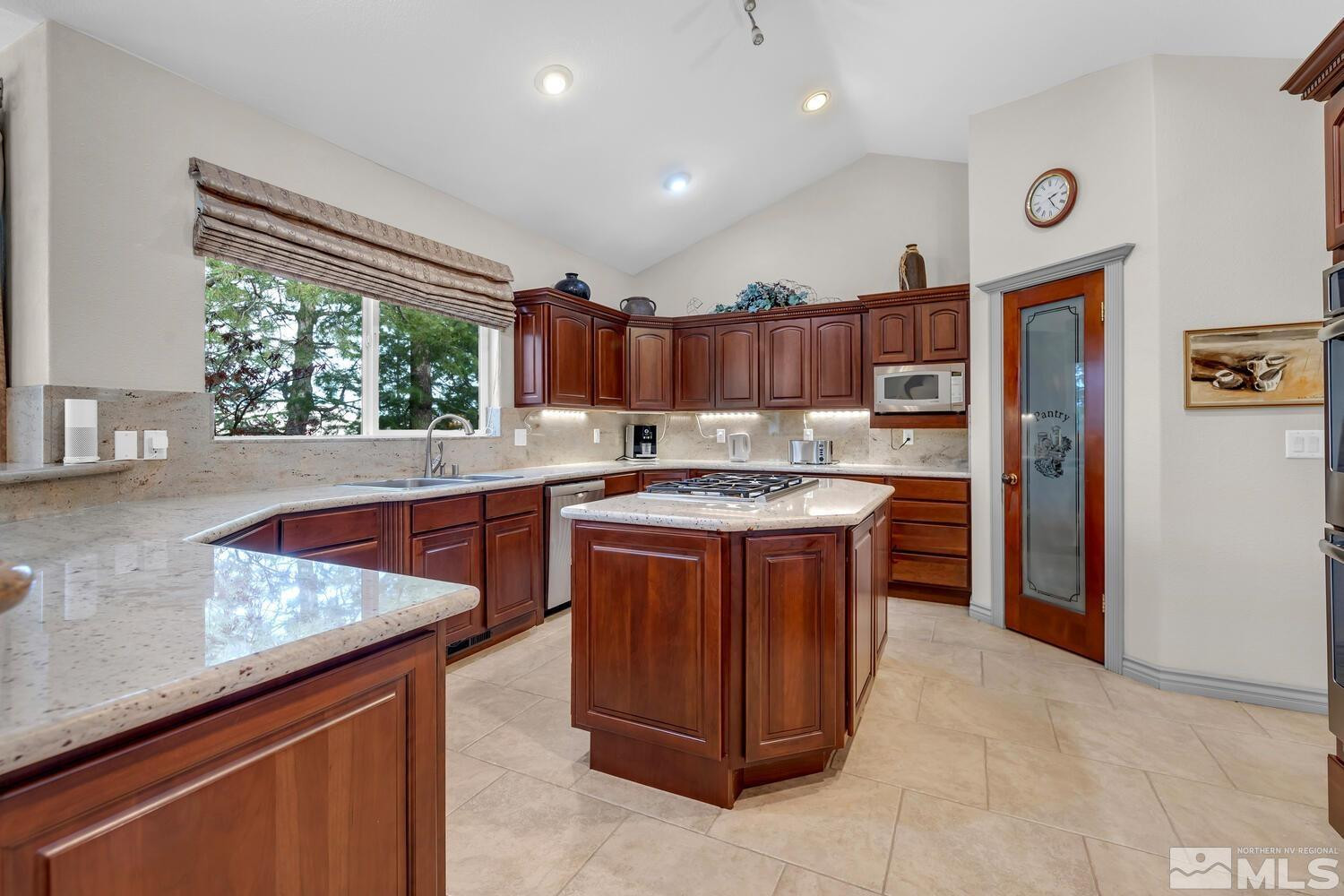 1465 Wolf Run Road Reno, NV 89511 - Photo 14 of 40 a kitchen with stainless steel appliances granite countertop a stove a sink and a refrigerator