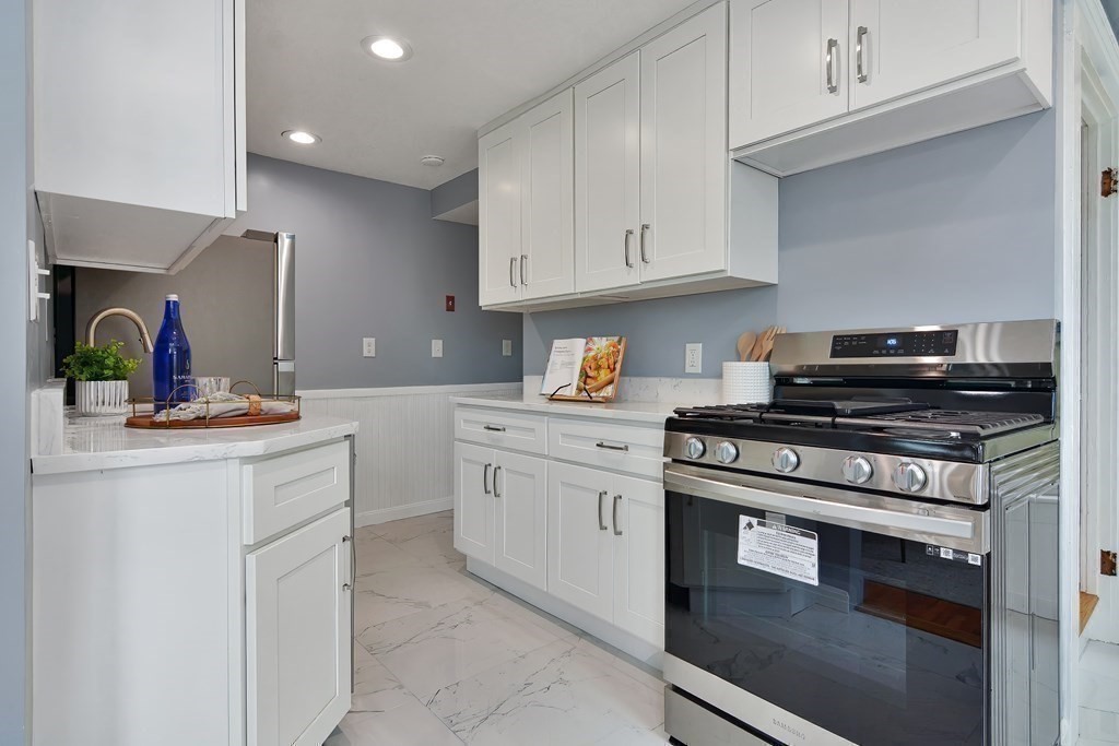 47 Moore Street Lowell, MA 01852 - Photo 12 of 36 a kitchen with white cabinets and appliances