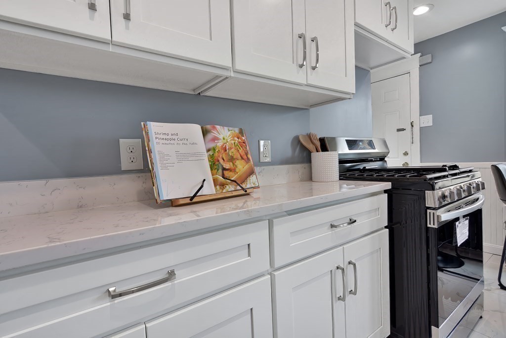 47 Moore Street Lowell, MA 01852 - Photo 14 of 36 a kitchen with stainless steel appliances granite countertop white cabinets and a stove