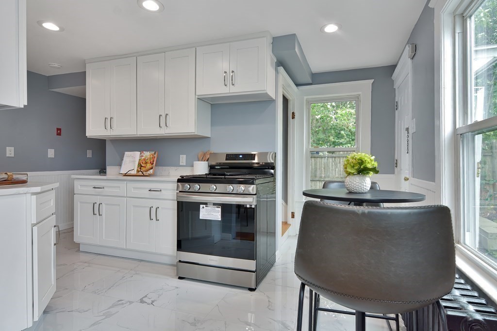 47 Moore Street Lowell, MA 01852 - Photo 16 of 36 a kitchen with stainless steel appliances granite countertop a stove a sink and a refrigerator