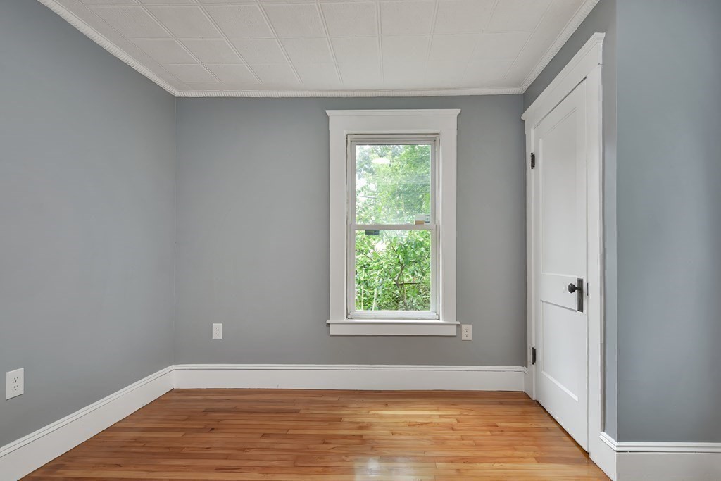 47 Moore Street Lowell, MA 01852 - Photo 18 of 36 a view of an empty room with wooden floor and a window