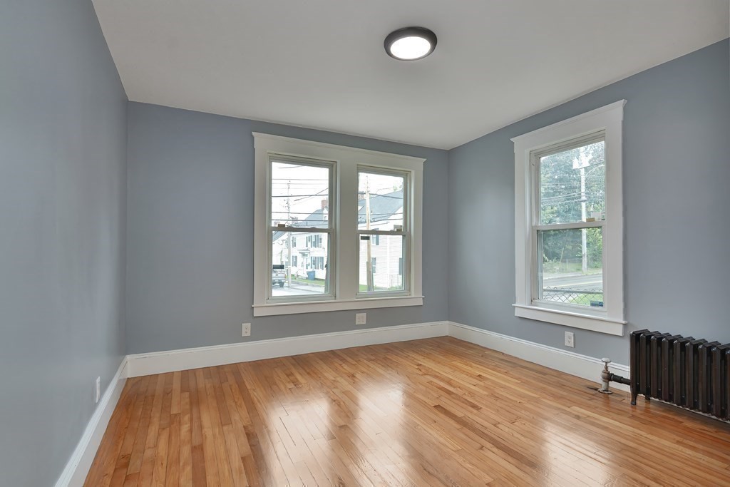 47 Moore Street Lowell, MA 01852 - Photo 20 of 36 an empty room with wooden floor and windows