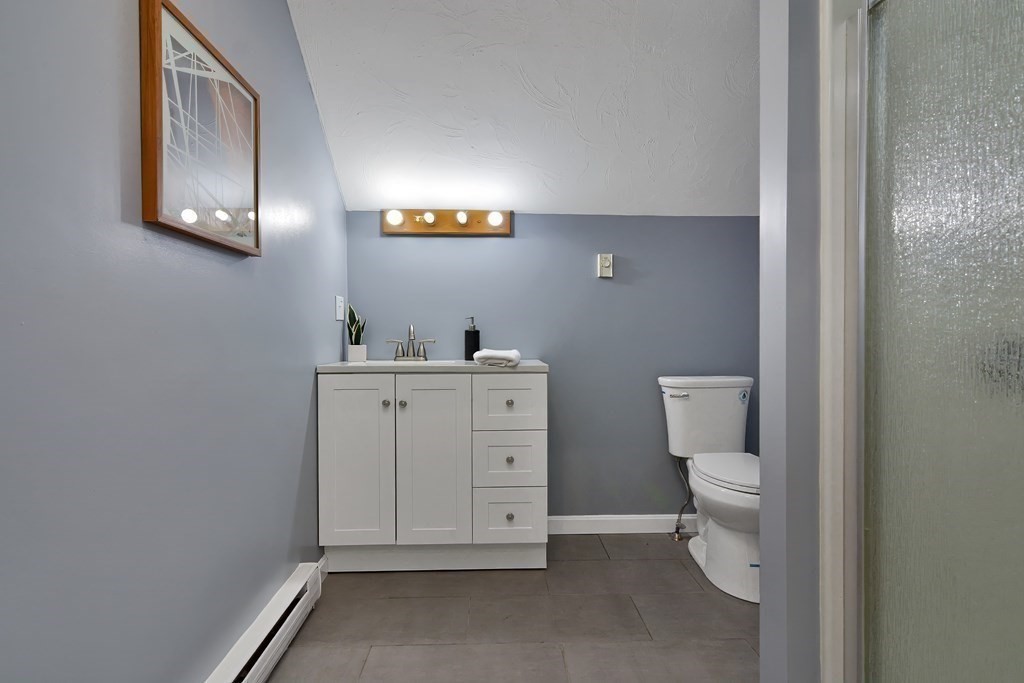 47 Moore Street Lowell, MA 01852 - Photo 33 of 36 a bathroom with a toilet sink vanity and mirror
