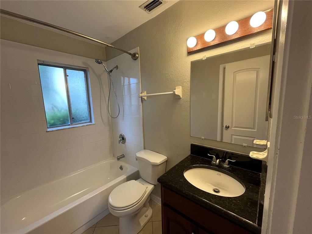 1239 East Ridgewood Street Orlando, FL 32803 - Photo 11 of 14 a bathroom with a double vanity sink toilet mirror and shower