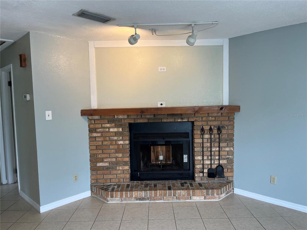 1239 East Ridgewood Street Orlando, FL 32803 - Photo 4 of 15 a fireplace with a clock on the wall