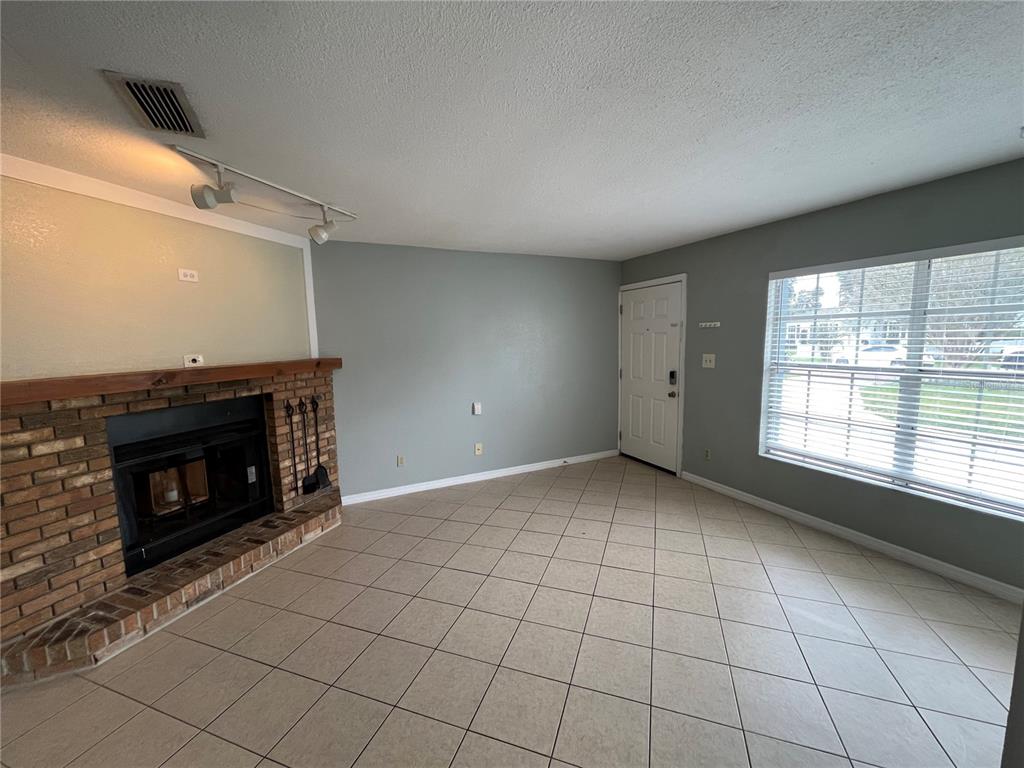 1239 East Ridgewood Street Orlando, FL 32803 - Photo 5 of 15 a view of an empty room with a fireplace and a window