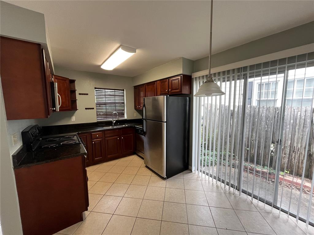 1239 East Ridgewood Street Orlando, FL 32803 - Photo 6 of 15 a kitchen with granite countertop a refrigerator and a sink