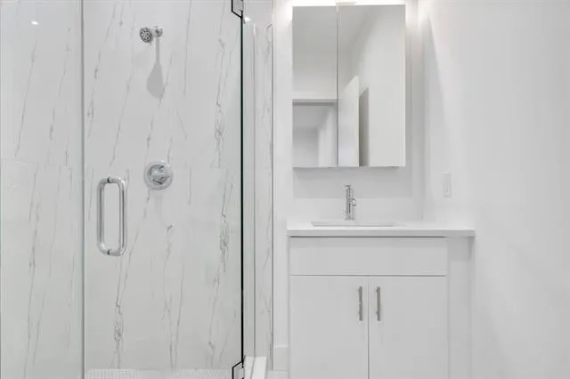 a bathroom with a sink a mirror and shower