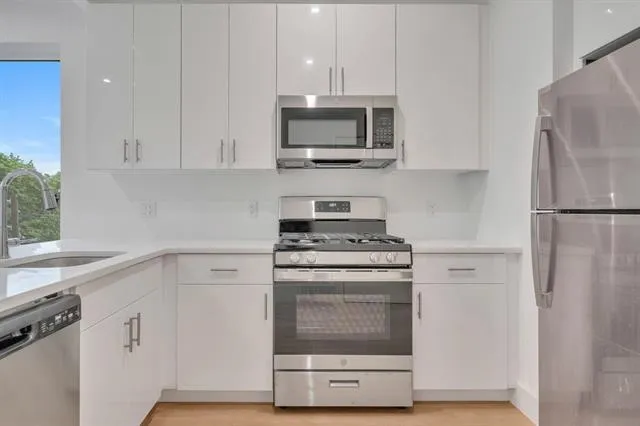 a kitchen with white cabinets and stainless steel appliances