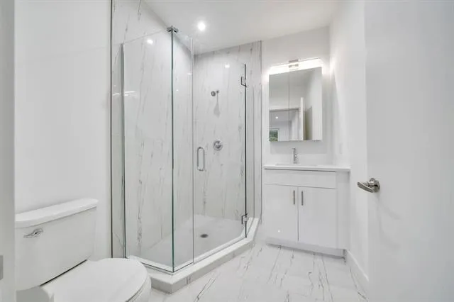 a bathroom with a shower a toilet and sink