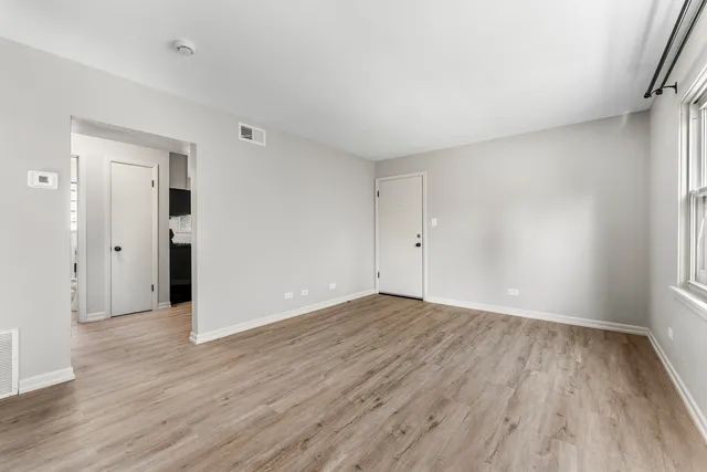a view of an empty room with wooden floor