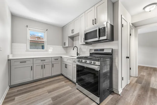 a kitchen with stainless steel appliances granite countertop a stove a sink and a microwave