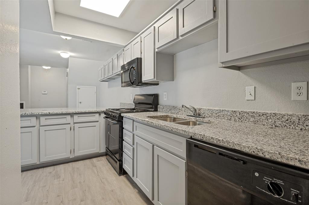 622 West Union Bower Road Irving, TX 75061 - Photo 5 of 13 Kitchen featuring light gray cabinetry, granite-finish countertops, stainless steel double basin sink, and black appliances including a range, microwave, and dishwasher