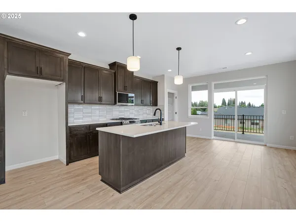 a kitchen with kitchen island a sink stainless steel appliances and cabinets