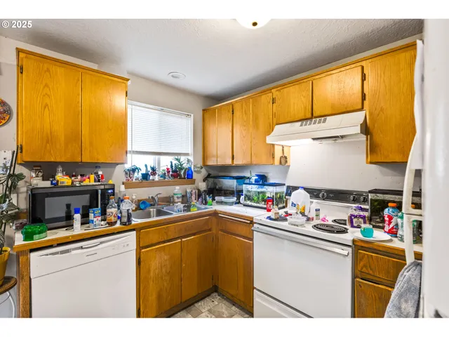 a kitchen with a window appliances and cabinets