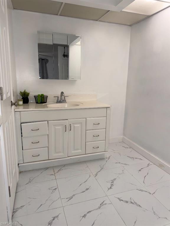 5395 Treetops Drive, Unit I Naples, FL 34113 - Photo 12 of 18 Bathroom vanity featuring a white cabinet with multiple drawers and a central double-door storage