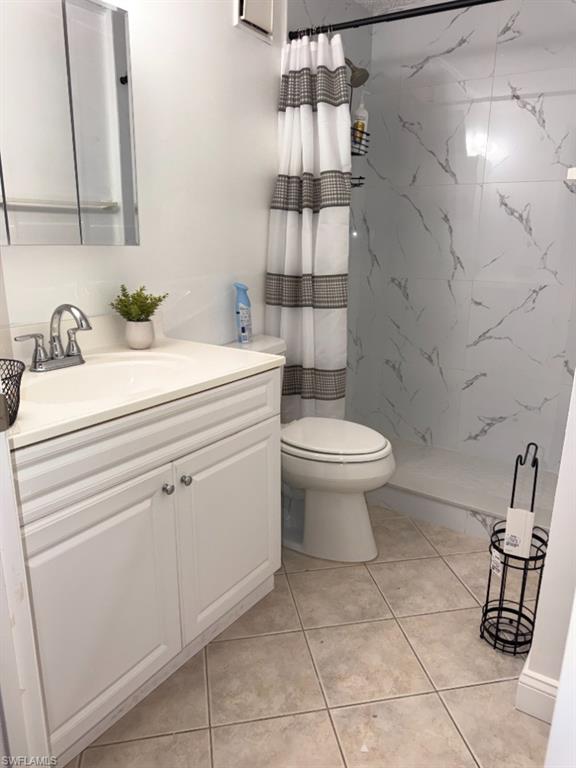 5395 Treetops Drive, Unit I Naples, FL 34113 - Photo 16 of 18 Bathroom featuring a white vanity with integrated sink, chrome faucet, and mirrored medicine cabinet