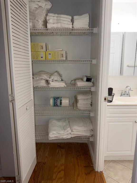 5395 Treetops Drive, Unit I Naples, FL 34113 - Photo 17 of 18 Built-in closet featuring louvered bi-fold doors, white wire shelving, and wood-finish flooring