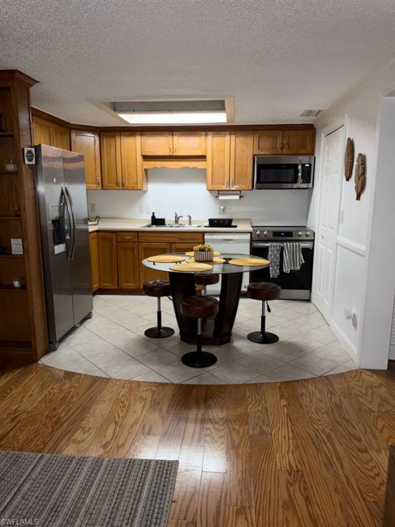 5395 Treetops Drive, Unit I Naples, FL 34113 - Photo 4 of 18 Kitchen featuring wood cabinetry, stainless steel appliances, and a tile floor