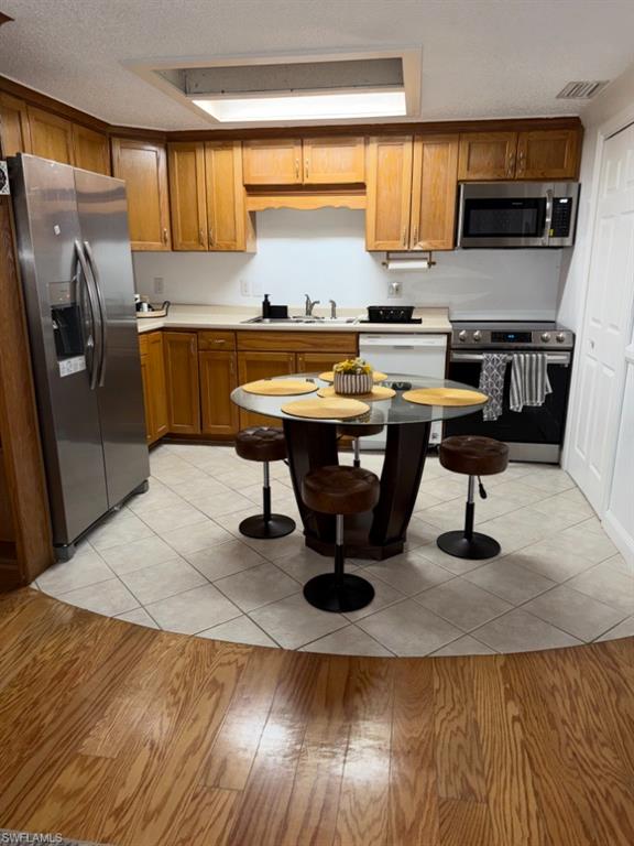 5395 Treetops Drive, Unit I Naples, FL 34113 - Photo 5 of 18 Kitchen featuring wood cabinetry, stainless steel appliances, and a skylight