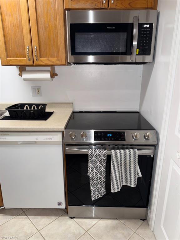 5395 Treetops Drive, Unit I Naples, FL 34113 - Photo 6 of 18 Stainless steel range with a smooth-top cook surface and coordinating over-range microwave