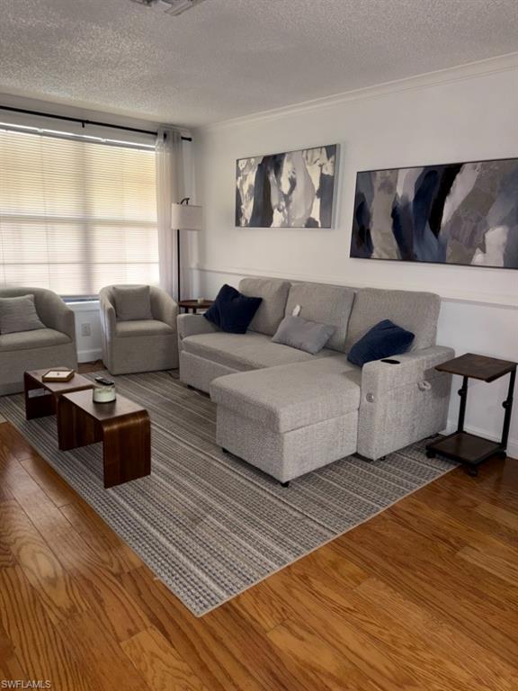 5395 Treetops Drive, Unit I Naples, FL 34113 - Photo 7 of 18 Living area featuring wood-finish flooring, white wall molding, and a large window with blinds
