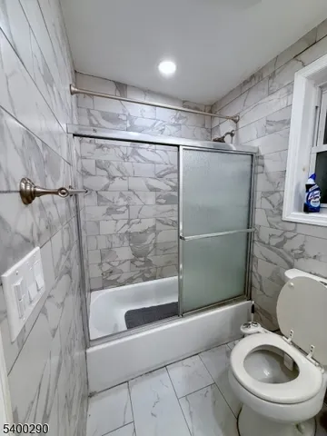 a bathroom with a granite countertop bathtub shower and toilet