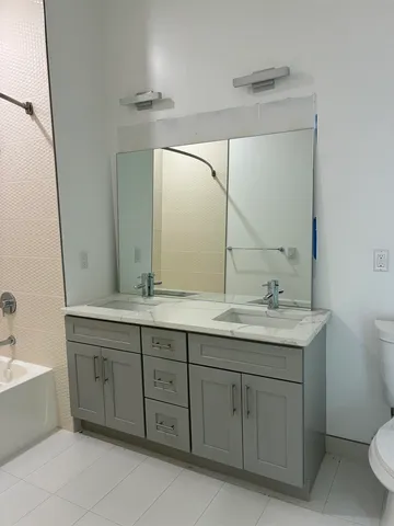 a bathroom with a granite countertop sink a toilet and a mirror