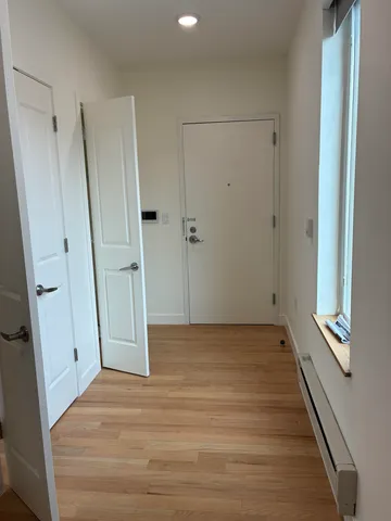 a view of a hallway with wooden floor and staircase