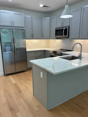 a kitchen with stainless steel appliances granite countertop a sink stove and refrigerator