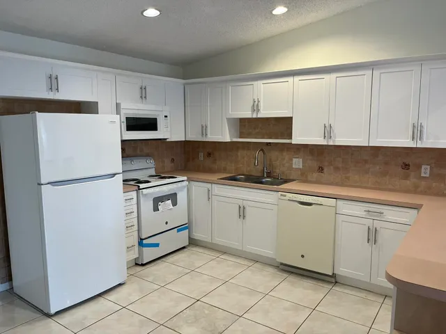 a kitchen with cabinets stainless steel appliances and a sink