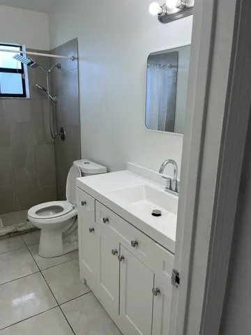 a bathroom with a sink a toilet a mirror and vanity
