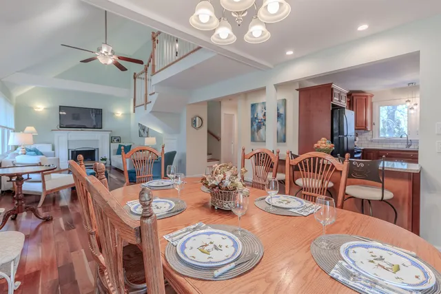 a dining room with wooden floor a chandelier a wooden table and chairs