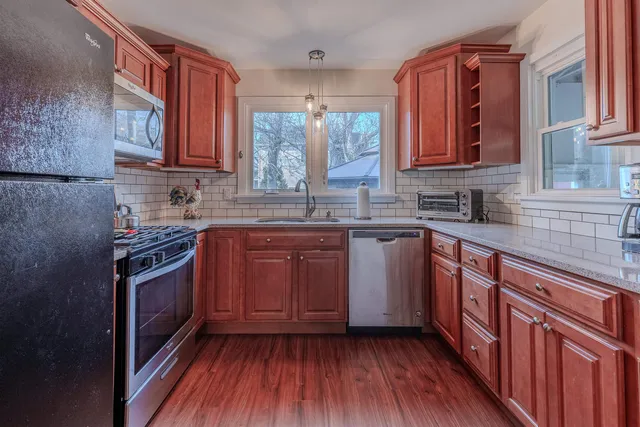 a kitchen with stainless steel appliances granite countertop a sink stove and cabinets