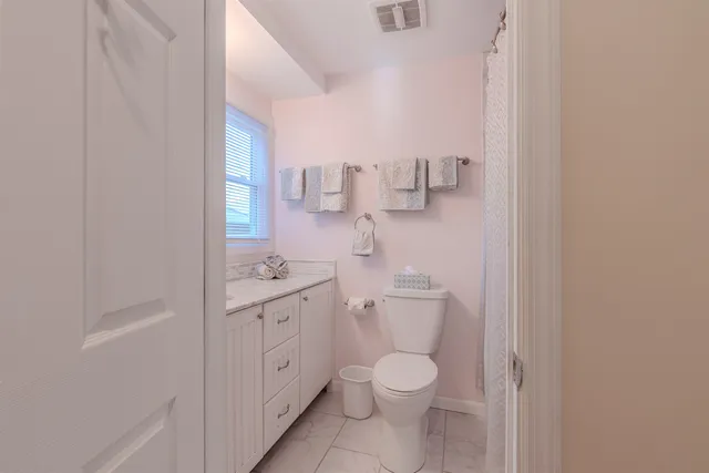a bathroom with a toilet a sink and a window