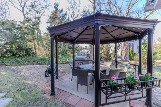 a view of a patio with a table chairs and a backyard