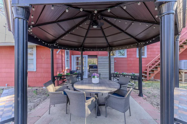 a view of a patio with a table and chairs under an umbrella