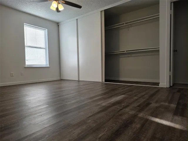 a view of empty room with wooden floor and window