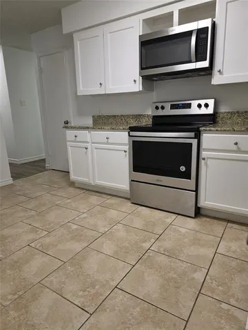 a kitchen with stainless steel appliances a stove a sink and a microwave