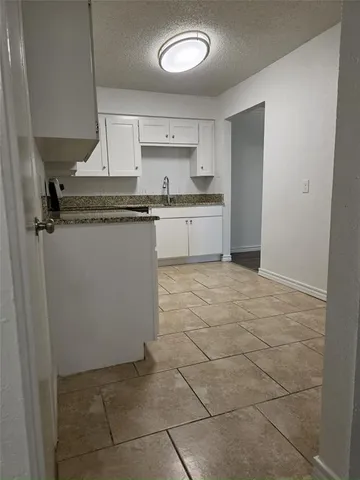 a kitchen with a sink a stove cabinets and a refrigerator