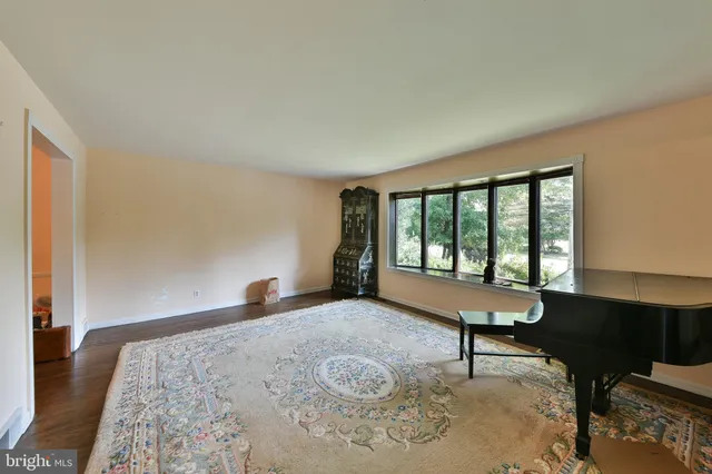 a kitchen with stainless steel appliances granite countertop a refrigerator a sink dishwasher a stove and white countertops with wooden floor