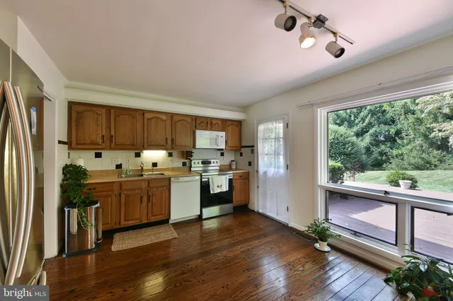 a kitchen with granite countertop stainless steel appliances a refrigerator and a stove top oven