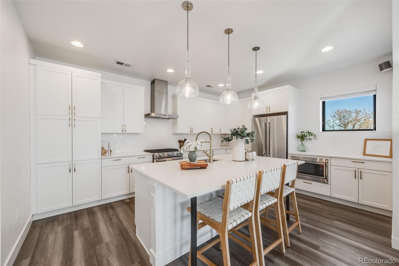 3011 West 53rd Avenue Denver, CO 80221 - Photo 12 of 44 a kitchen with a dining table chairs stove and white cabinets