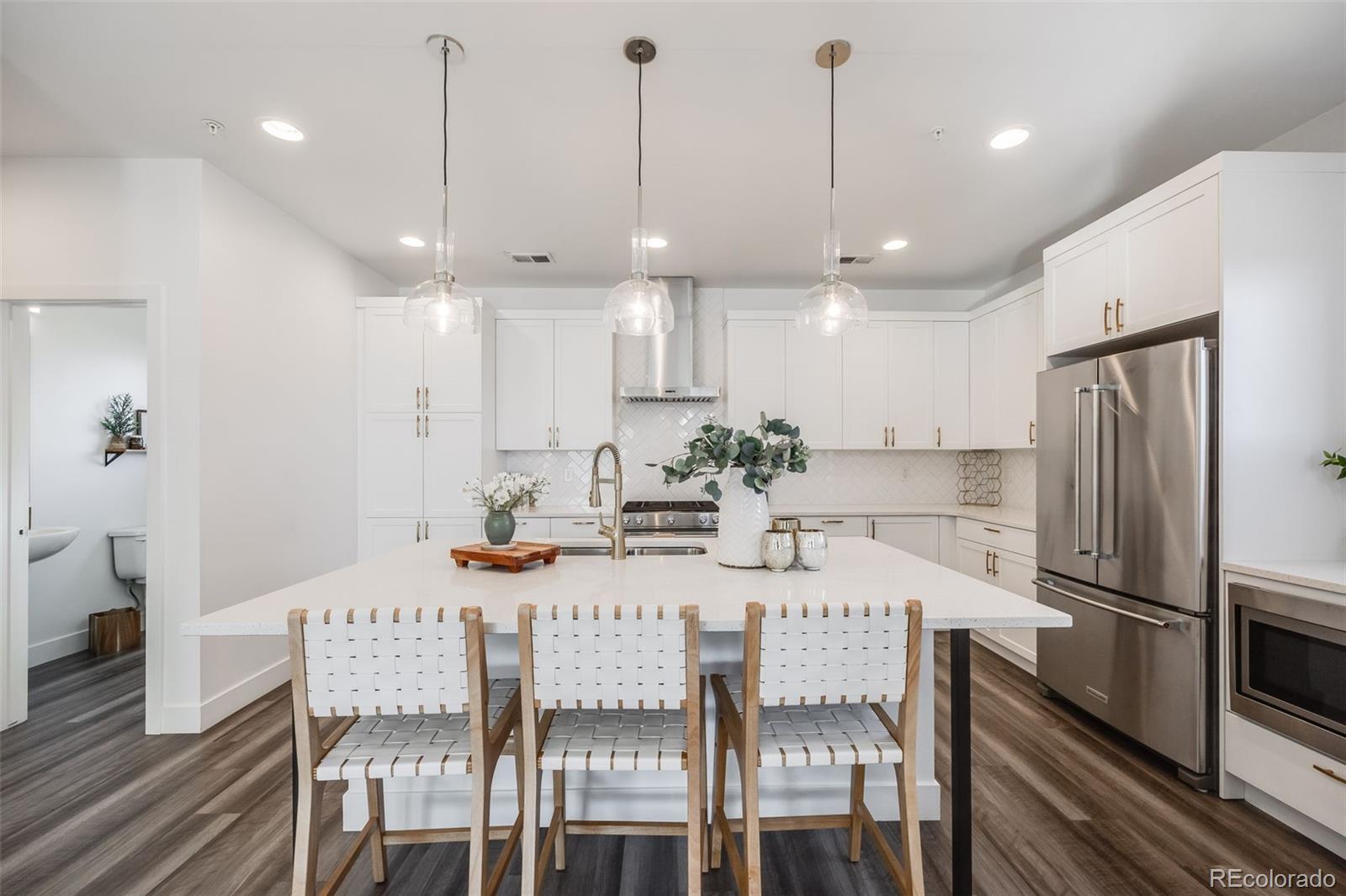 3011 West 53rd Avenue Denver, CO 80221 - Photo 13 of 44 a kitchen with stainless steel appliances granite countertop a dining table chairs refrigerator and microwave
